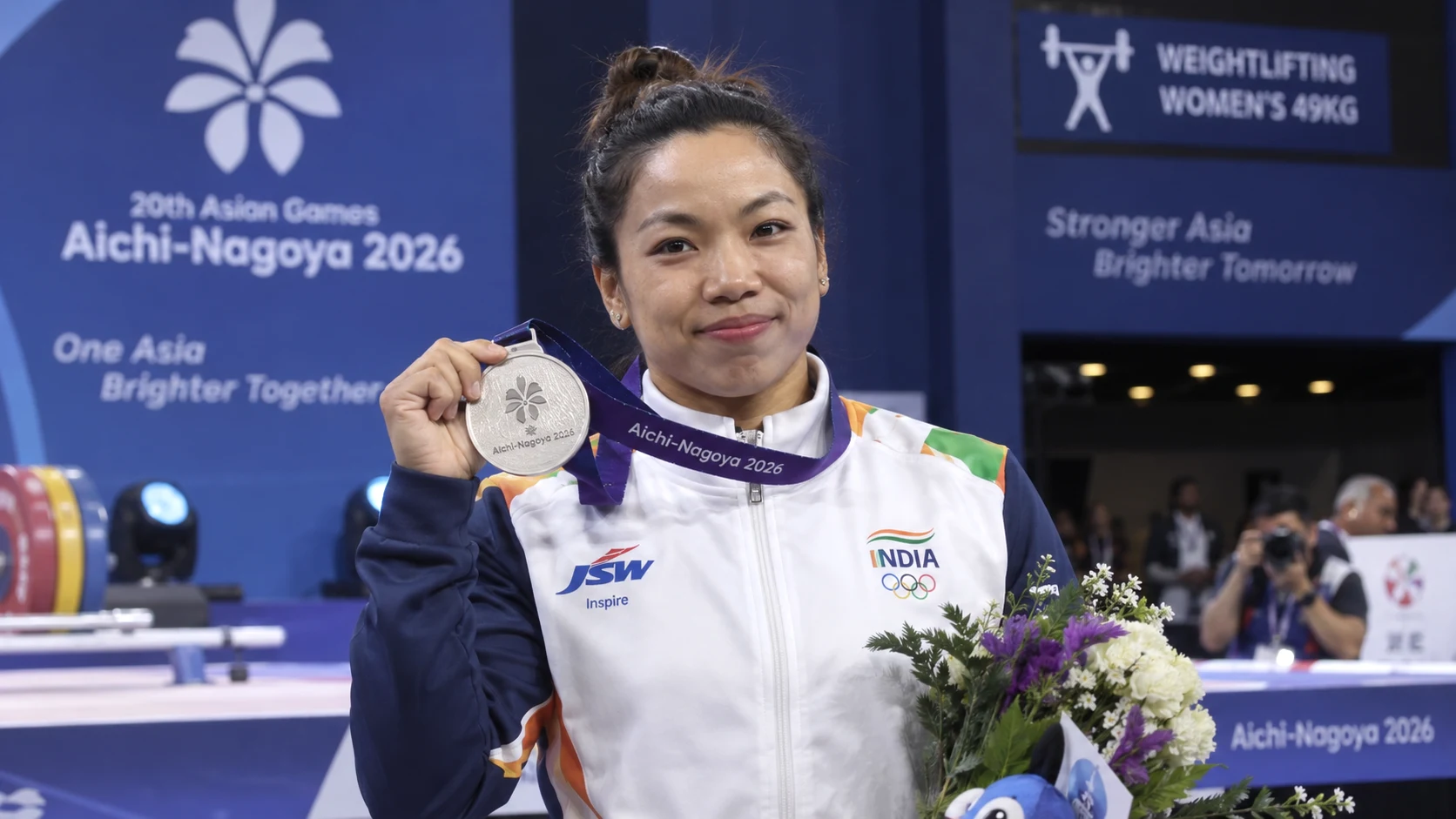 Mirabai Chanu holding her silver medal after finishing second in the women's 49kg weightlifting event at the Asian Games 2026 in Nagoya